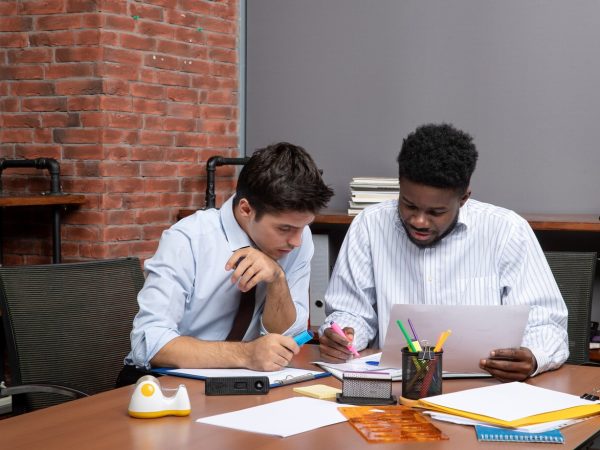 front-view-work-process-two-businessmen-discussing-project-while-sitting-desk_140725-109588